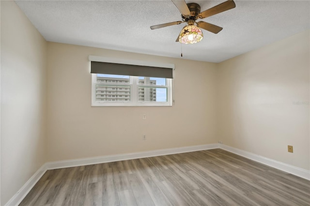 unfurnished room with ceiling fan, a textured ceiling, and wood-type flooring