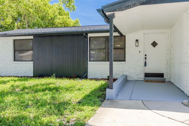 entrance to property featuring a yard