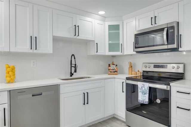 kitchen featuring white cabinetry, light hardwood / wood-style floors, appliances with stainless steel finishes, and sink