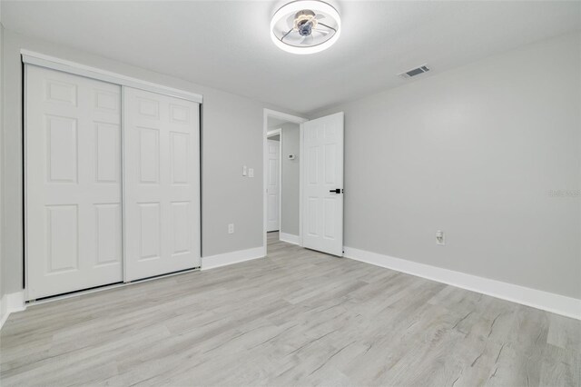 unfurnished bedroom featuring light hardwood / wood-style flooring and a closet