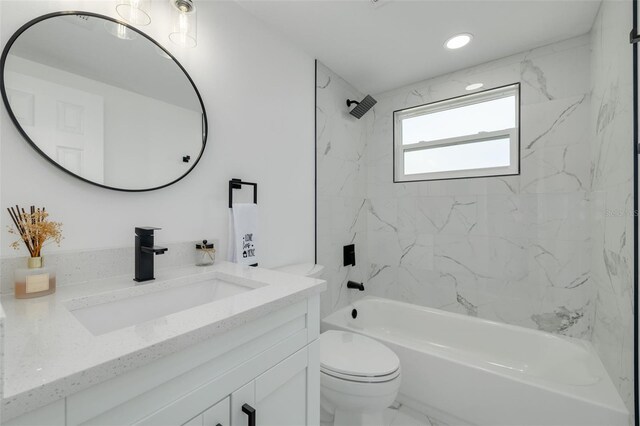 full bathroom featuring vanity, tiled shower / bath combo, and toilet