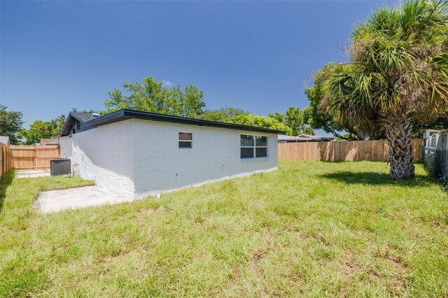 rear view of house with a yard and central AC unit