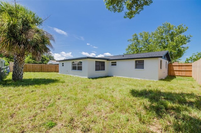 back of property featuring a lawn