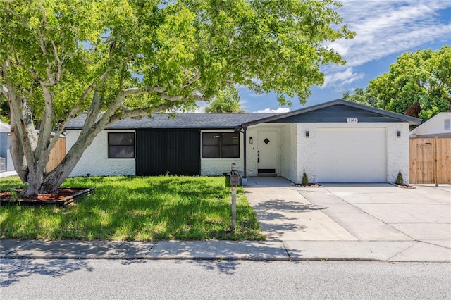 ranch-style house with a garage and a front lawn