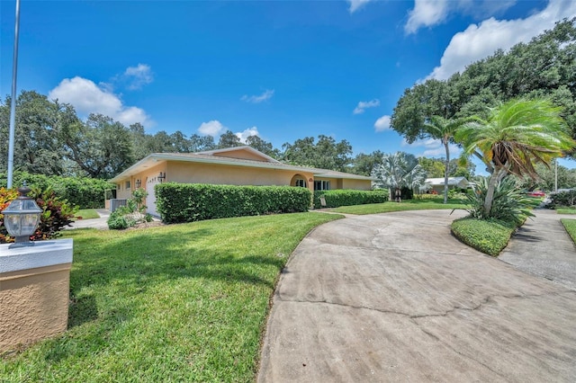 view of front of property featuring a front yard and cooling unit