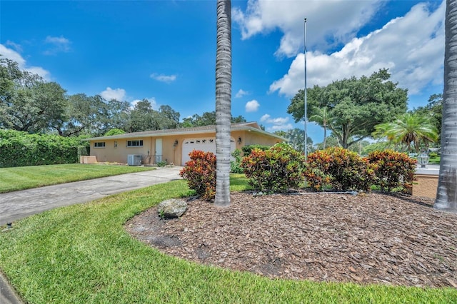 ranch-style home with cooling unit, a garage, and a front yard