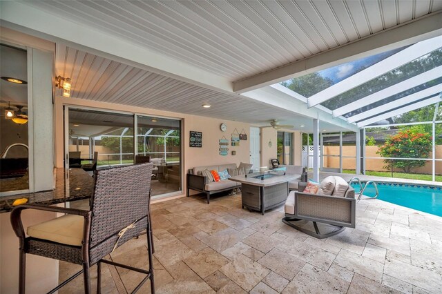 sunroom featuring vaulted ceiling with skylight, plenty of natural light, and ceiling fan