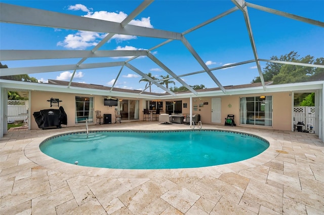 view of swimming pool featuring a patio area and a lanai