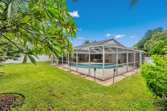 view of swimming pool with a patio area, a lawn, and glass enclosure