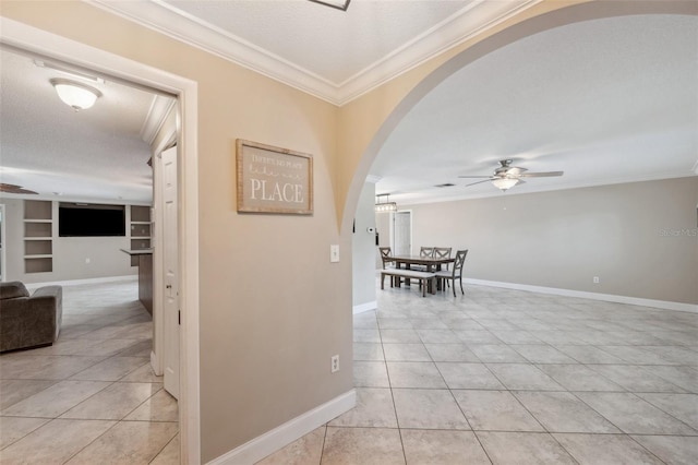 hall featuring light tile patterned flooring, built in features, crown molding, and a textured ceiling