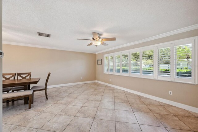 tiled dining area featuring a textured ceiling, ceiling fan, and crown molding