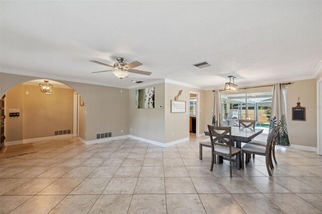 tiled dining area featuring ceiling fan with notable chandelier, a textured ceiling, and ornamental molding