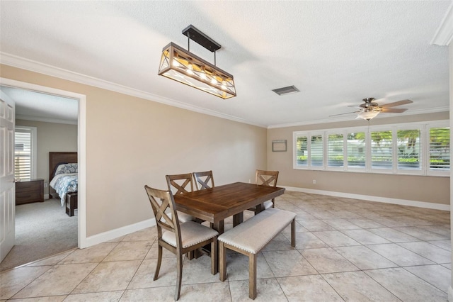 tiled dining space featuring ornamental molding, a textured ceiling, and ceiling fan