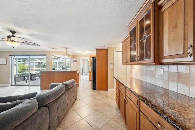 kitchen featuring tasteful backsplash, ceiling fan, hanging light fixtures, stainless steel fridge, and light tile patterned floors