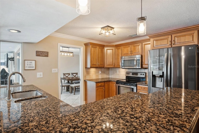 kitchen with dark stone countertops, appliances with stainless steel finishes, sink, and a textured ceiling