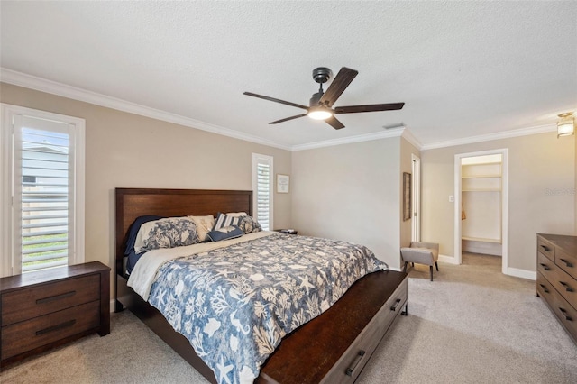 bedroom with a spacious closet, ceiling fan, crown molding, light colored carpet, and a textured ceiling