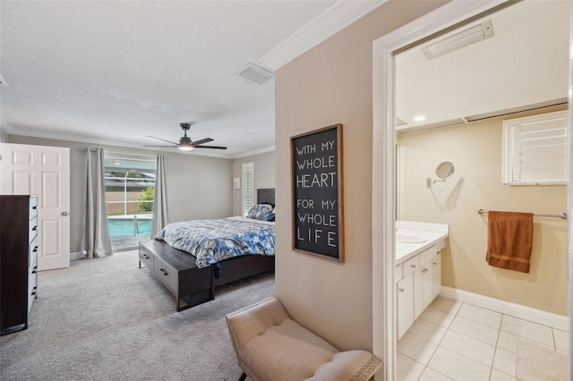 tiled bedroom with access to outside, a textured ceiling, ceiling fan, and ornamental molding