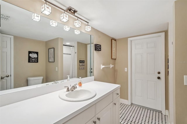 bathroom with vanity, tile patterned floors, and toilet