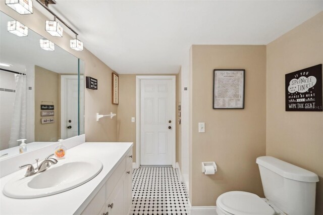 bathroom featuring vanity, tile patterned floors, and toilet