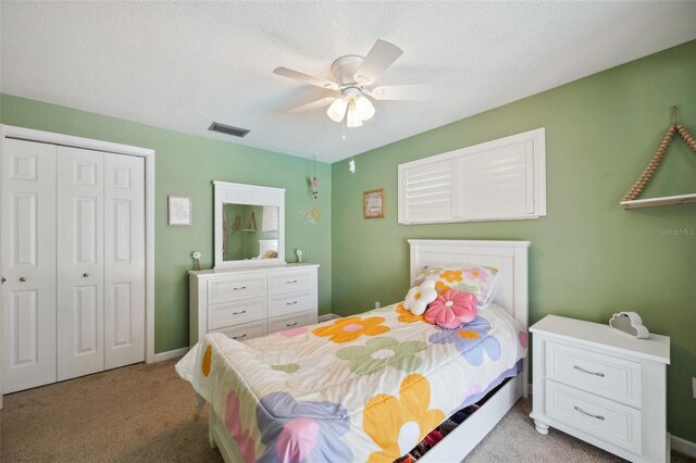 bedroom featuring light colored carpet, a closet, a textured ceiling, and ceiling fan