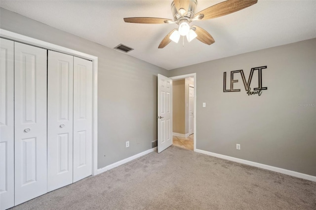 unfurnished bedroom with a closet, ceiling fan, and light colored carpet