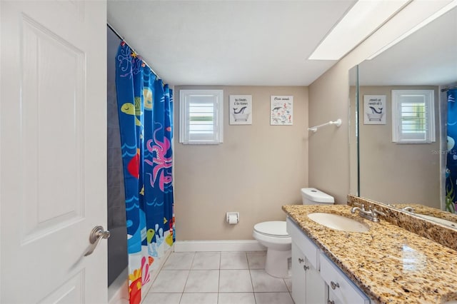 bathroom featuring tile patterned flooring, a healthy amount of sunlight, toilet, and vanity