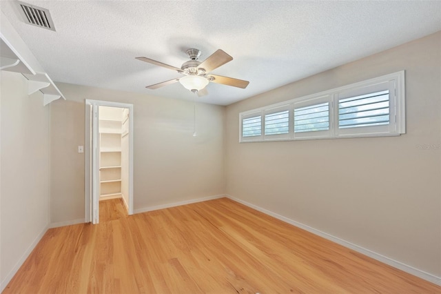 interior space featuring light wood-type flooring, ceiling fan, and a textured ceiling