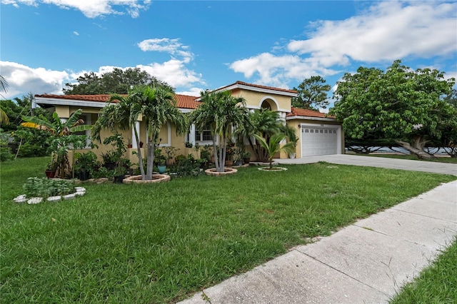 mediterranean / spanish home featuring a garage and a front yard