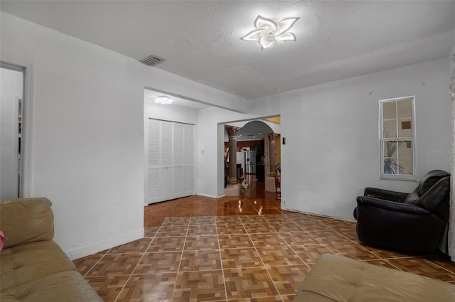 living room featuring parquet floors and a textured ceiling