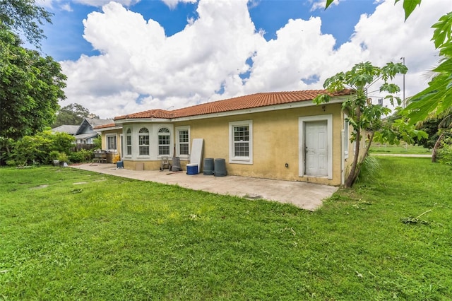 rear view of property featuring a patio and a lawn