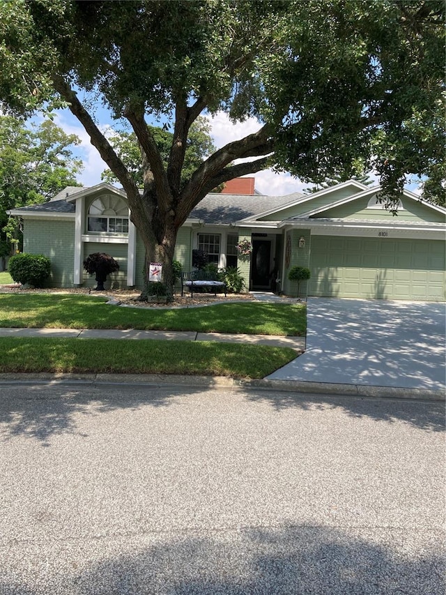 single story home with a garage and a front lawn