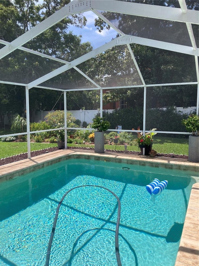 view of pool featuring glass enclosure