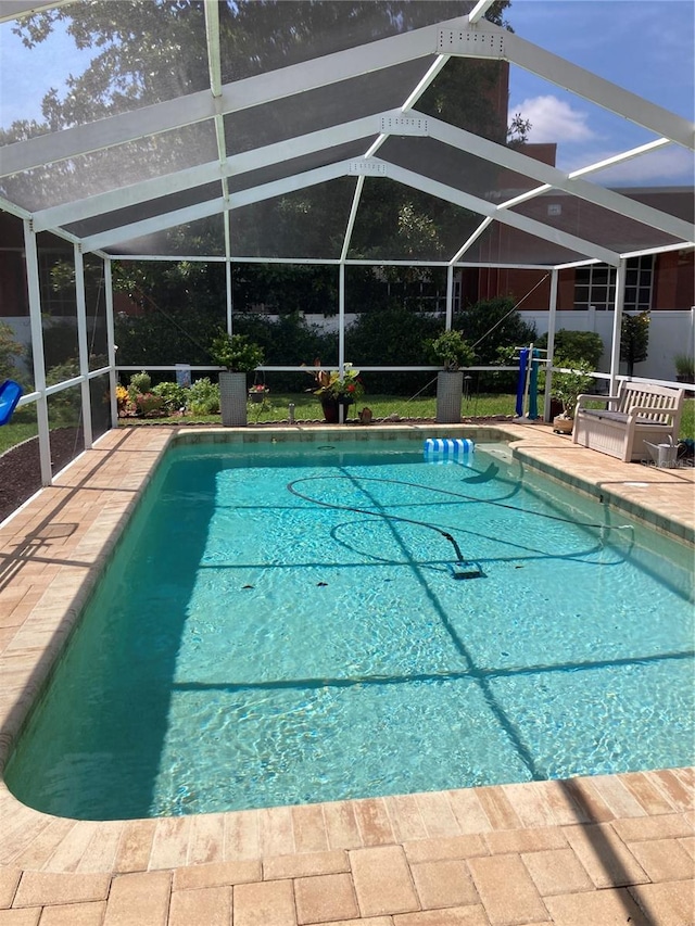 view of pool featuring glass enclosure