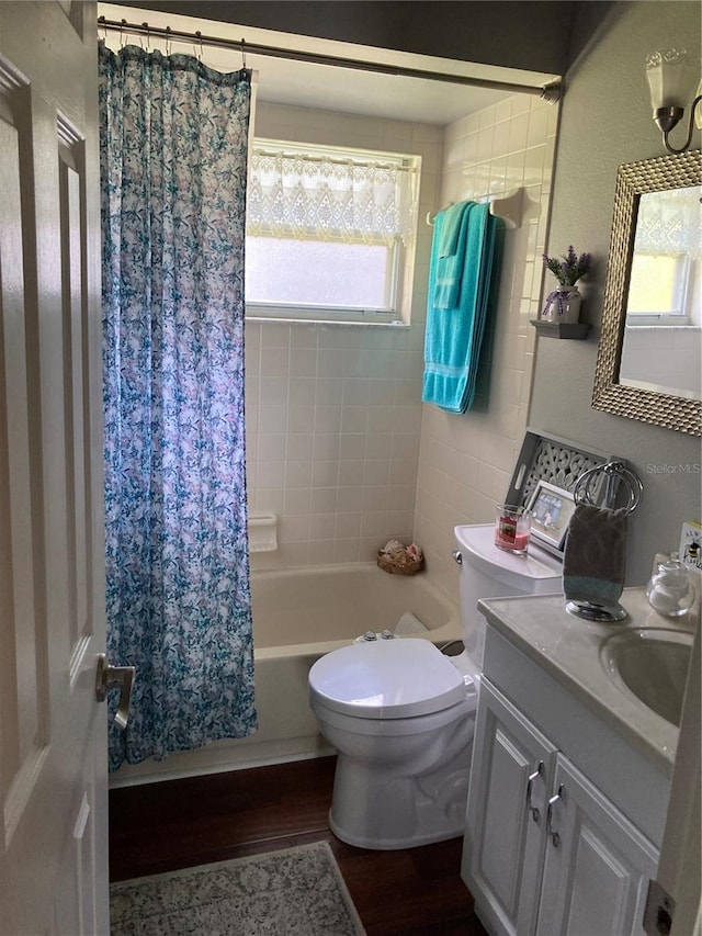 full bathroom featuring toilet, plenty of natural light, vanity, and wood-type flooring