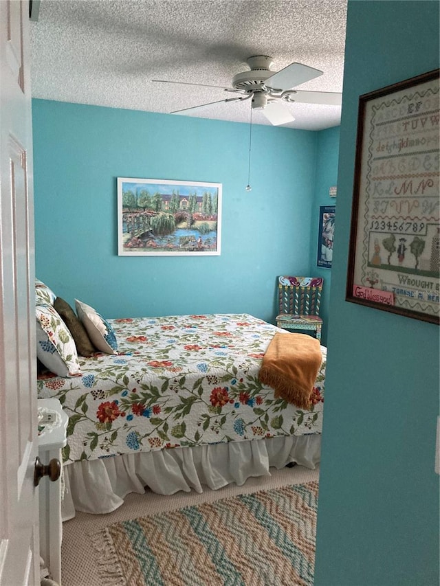 bedroom featuring a textured ceiling, carpet flooring, and ceiling fan