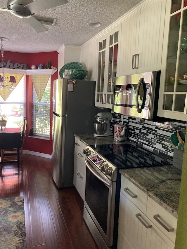 kitchen featuring ceiling fan, dark stone counters, range with electric cooktop, dark wood-type flooring, and backsplash