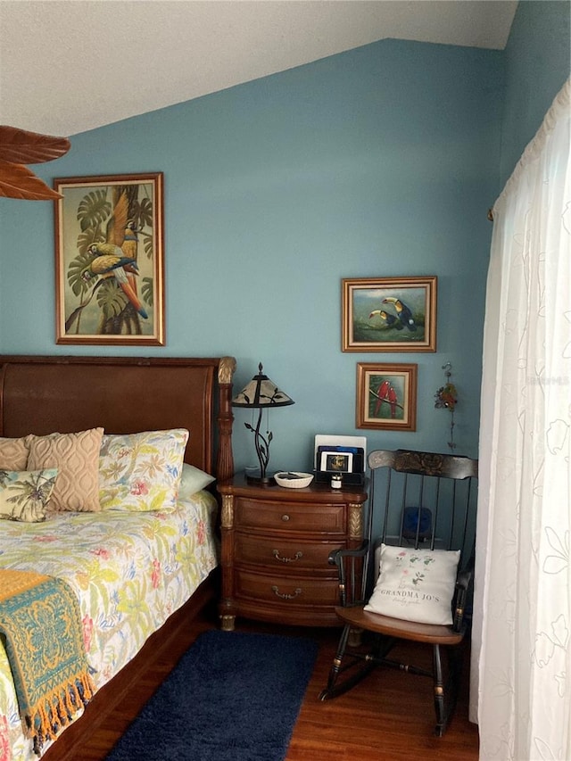 bedroom with wood-type flooring and vaulted ceiling