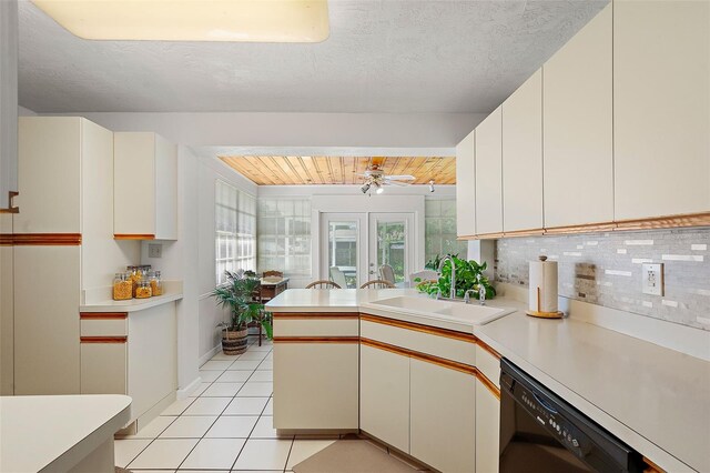 kitchen featuring white cabinetry, dishwasher, sink, backsplash, and light tile patterned floors