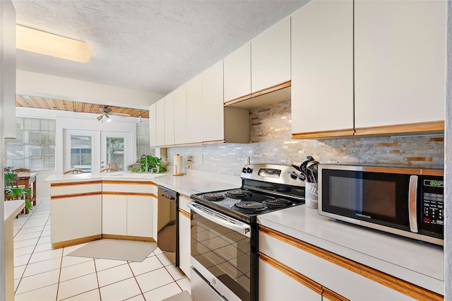 kitchen with white cabinetry, light tile patterned floors, kitchen peninsula, and appliances with stainless steel finishes