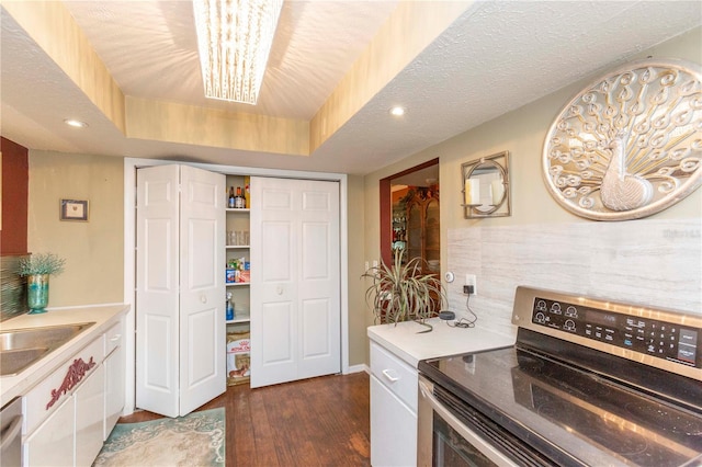 kitchen featuring a chandelier, a textured ceiling, a tray ceiling, electric stove, and dark hardwood / wood-style floors