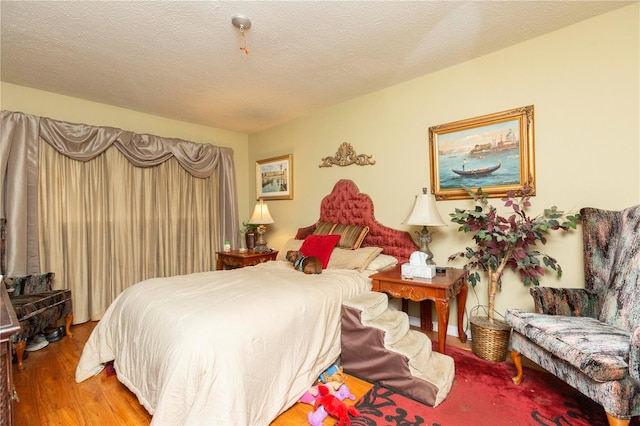 bedroom with hardwood / wood-style flooring and a textured ceiling