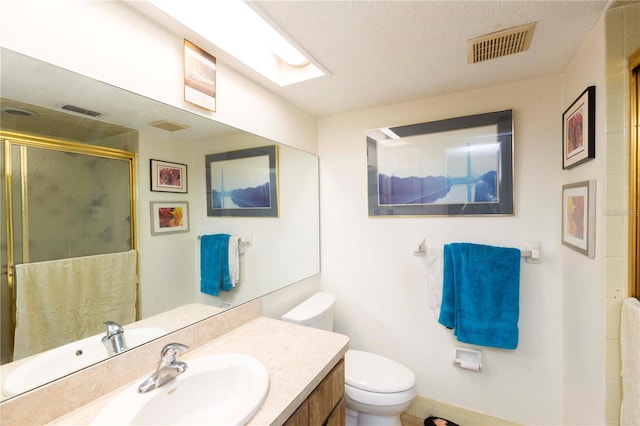 bathroom featuring vanity, toilet, and a textured ceiling