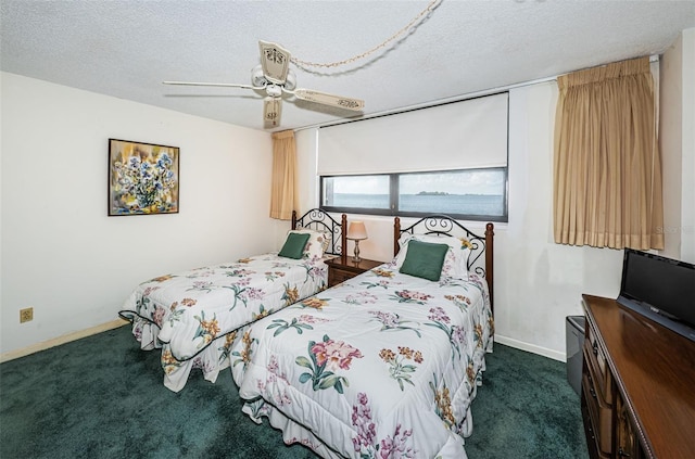 bedroom featuring a textured ceiling, dark carpet, a ceiling fan, and baseboards