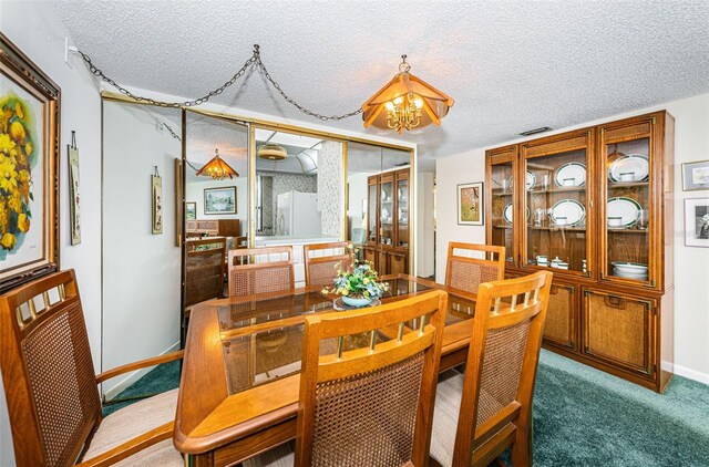 carpeted dining room featuring a notable chandelier, a textured ceiling, and baseboards