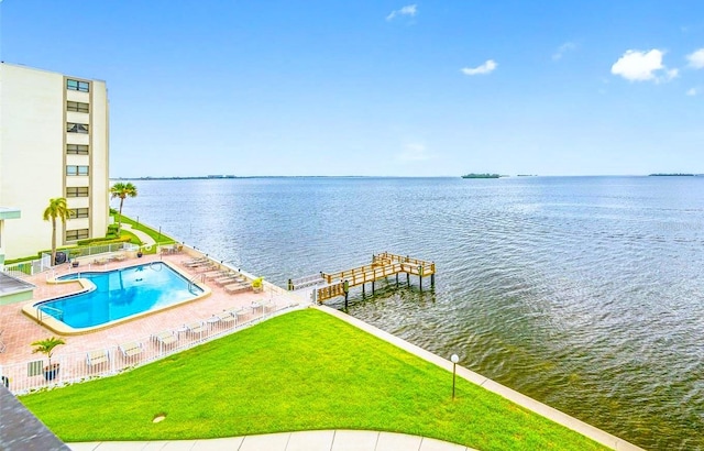 exterior space with a patio area, a yard, a community pool, and a water view