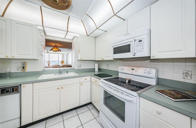 kitchen featuring light tile patterned floors, sink, white appliances, and white cabinetry