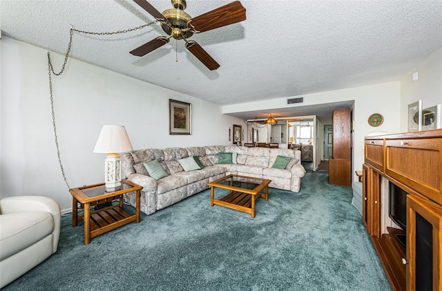 carpeted living room featuring a textured ceiling and ceiling fan