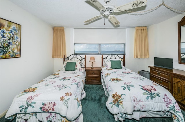 bedroom featuring a textured ceiling, ceiling fan, and dark carpet