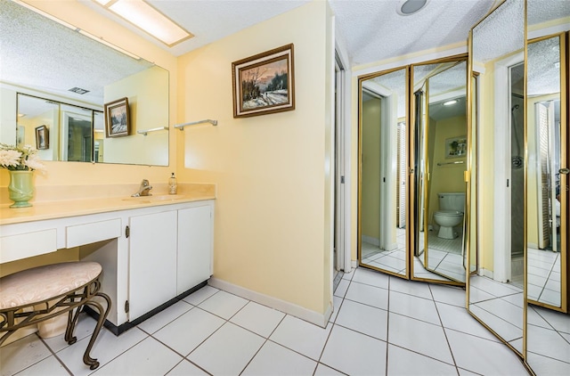 bathroom featuring tile patterned floors, toilet, and vanity