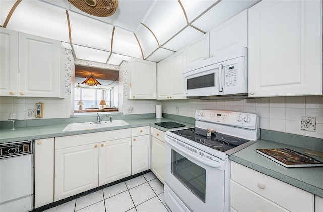300 Woodette Dr Unit 202B, Dunedin, FL 34698 - kitchen with white appliances, backsplash, white cabinets, and light tile patterned floors